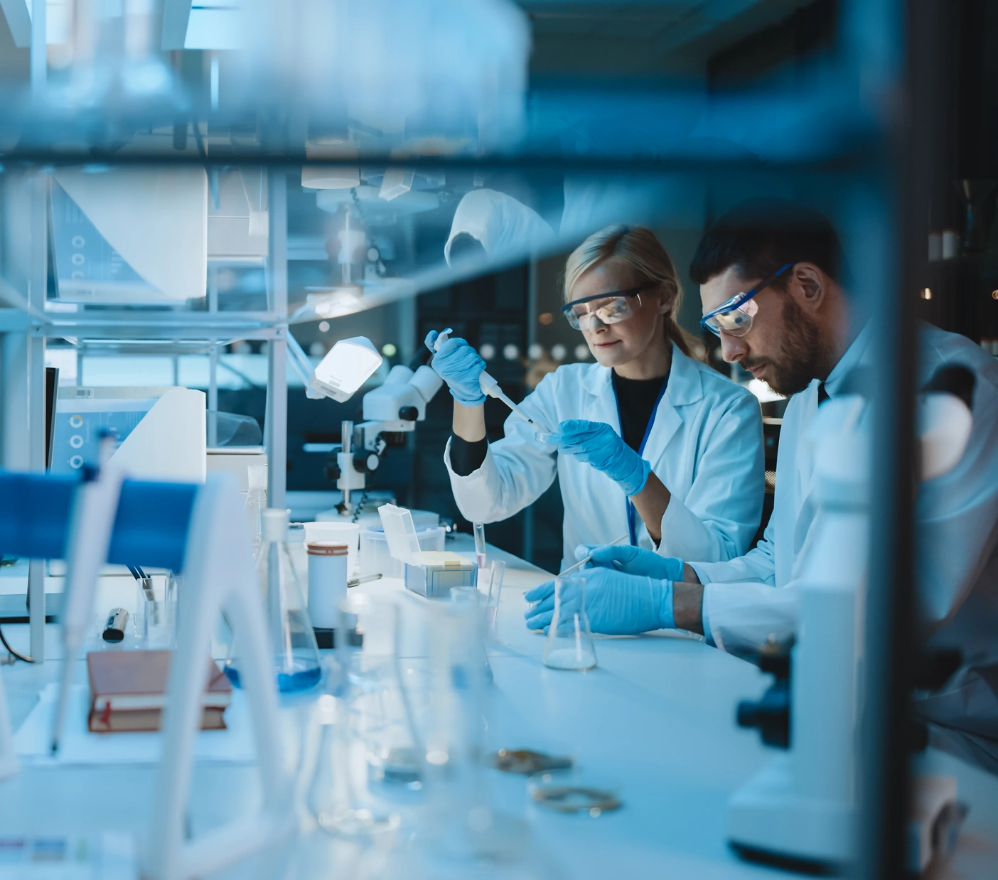 Scientists in a lab, collaborating on experiments. Explore innovation with BeOne Careers.